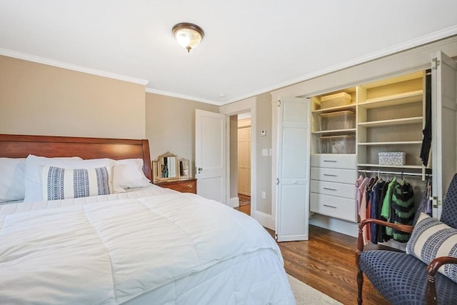 bedroom featuring dark wood finished floors, crown molding, baseboards, and a closet