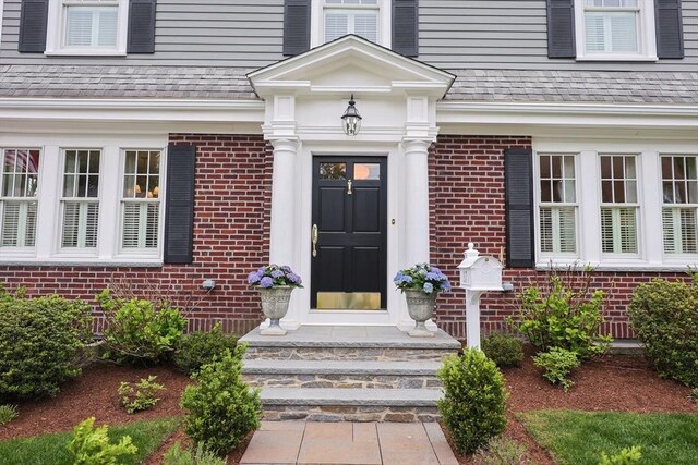 doorway to property featuring brick siding