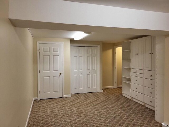 unfurnished bedroom with baseboards, a closet, and dark carpet
