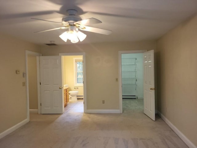 unfurnished bedroom featuring baseboards, a baseboard radiator, ensuite bathroom, and light colored carpet