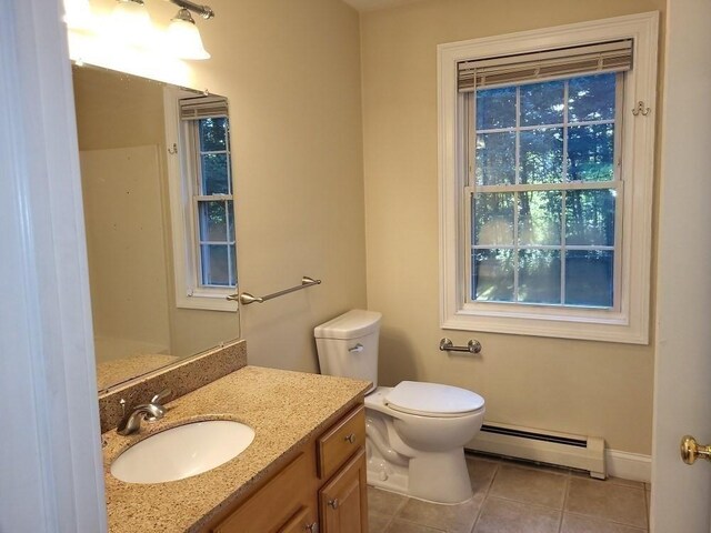 bathroom featuring baseboards, toilet, vanity, a baseboard heating unit, and tile patterned flooring