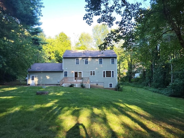 back of property featuring a deck and a yard