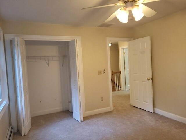 unfurnished bedroom with a baseboard radiator, baseboards, and carpet