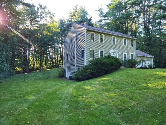 colonial house with cooling unit, fence, and a front lawn