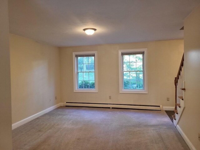 unfurnished room with carpet, baseboards, stairs, and baseboard heating