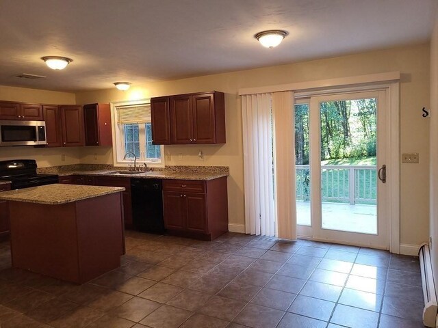 kitchen with visible vents, a baseboard radiator, dark tile patterned flooring, a sink, and black appliances