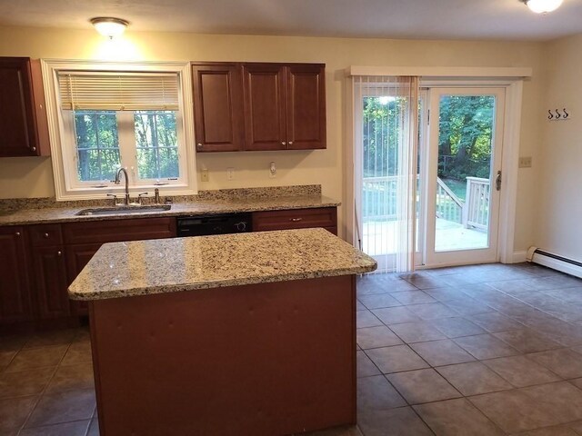 kitchen featuring tile patterned flooring, a kitchen island, a sink, black dishwasher, and light stone countertops