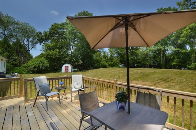 64 Charlotte White Rd Unit 2, Westport, MA 02790 - wooden deck featuring a storage unit, a lawn, outdoor dining area, and view of scattered trees