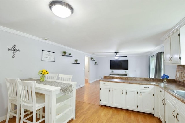 64 Charlotte White Rd Unit 2, Westport, MA 02790 - kitchen featuring a peninsula, ceiling fan, crown molding, white cabinetry, and light wood-style floors