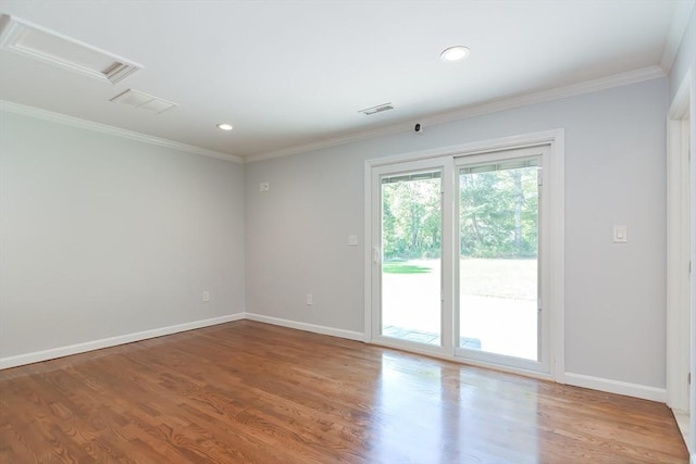 spare room with crown molding and wood-type flooring