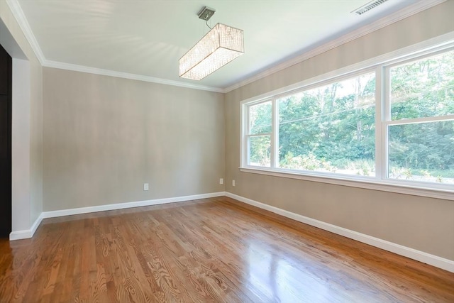 spare room featuring ornamental molding and light wood-type flooring