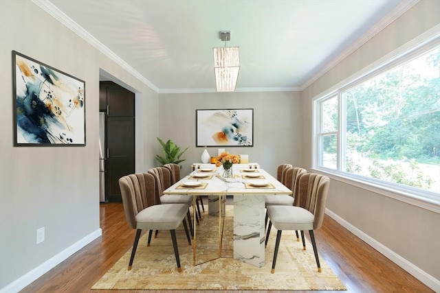 dining space featuring hardwood / wood-style floors and ornamental molding