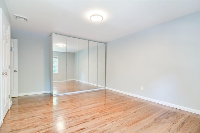 unfurnished bedroom featuring light hardwood / wood-style floors and a closet