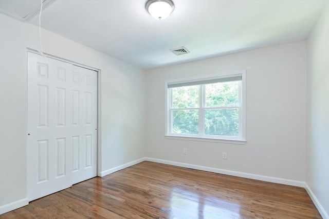 unfurnished bedroom with wood-type flooring and a closet