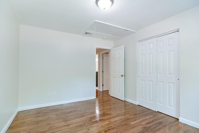 unfurnished bedroom with hardwood / wood-style flooring and a closet