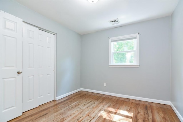 unfurnished bedroom with light hardwood / wood-style floors and a closet