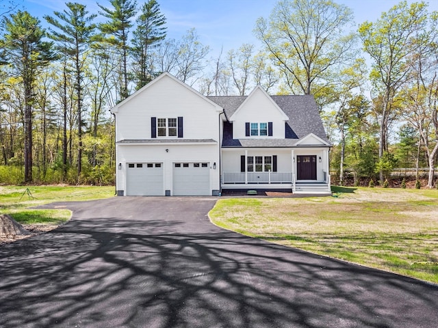 view of front facade with a garage, a front lawn, and a porch