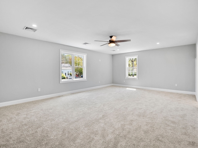 carpeted spare room with ceiling fan and a healthy amount of sunlight