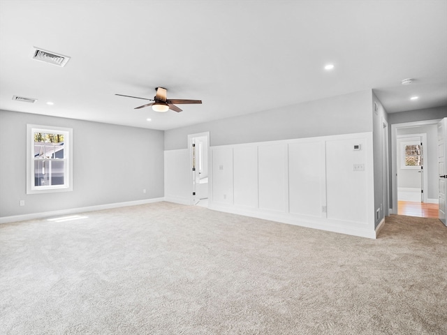 carpeted spare room with ceiling fan