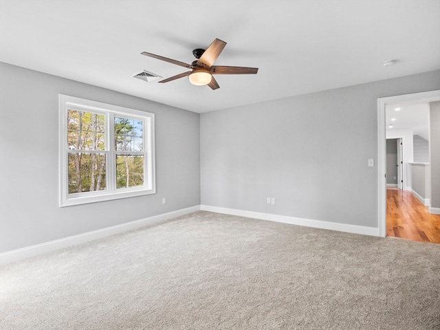 carpeted spare room featuring ceiling fan