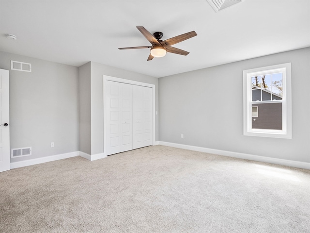 unfurnished bedroom featuring a closet, ceiling fan, and light colored carpet