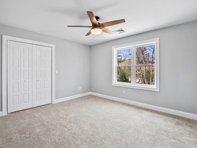 unfurnished bedroom with carpet floors, ceiling fan, and a closet