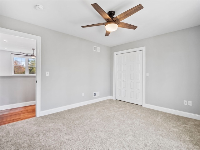 unfurnished bedroom featuring carpet floors, ceiling fan, and a closet