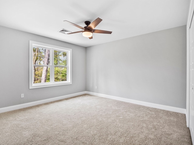 spare room featuring ceiling fan and carpet flooring