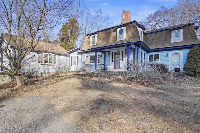 second empire-style home with covered porch and a chimney