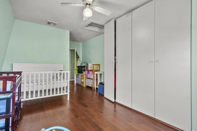 bedroom featuring a closet, visible vents, attic access, and wood finished floors