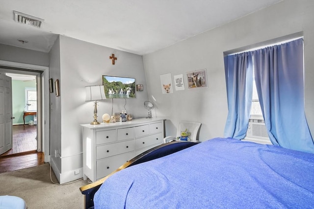 bedroom with visible vents, baseboards, carpet, and cooling unit