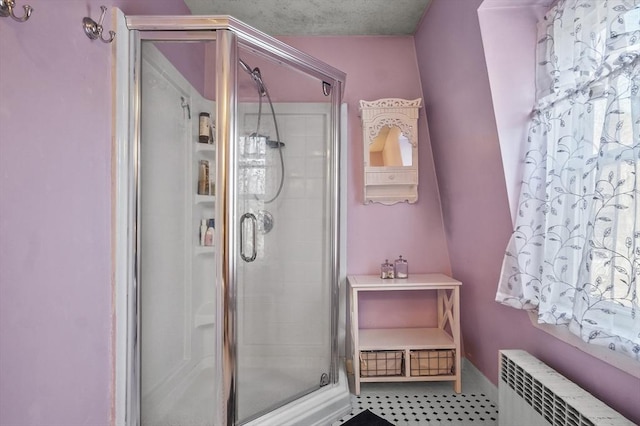 bathroom with a stall shower, radiator heating unit, and baseboards