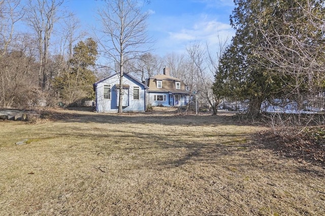 view of front of home with a front lawn and a chimney