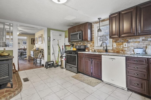 kitchen with visible vents, a sink, tasteful backsplash, stainless steel appliances, and ceiling fan