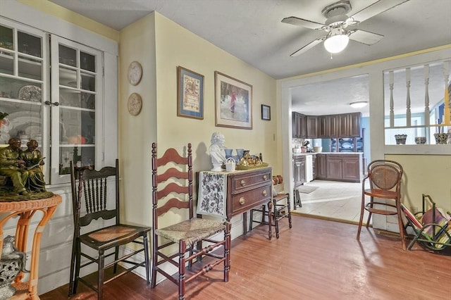 sitting room with light wood-style flooring and a ceiling fan