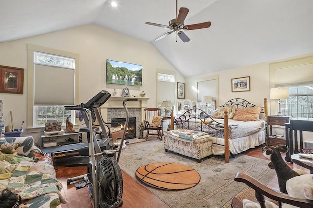 bedroom with lofted ceiling, wood finished floors, and a fireplace