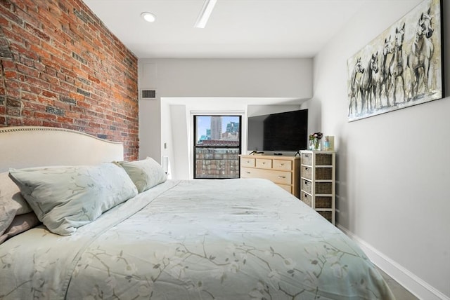 bedroom featuring baseboards, brick wall, and recessed lighting
