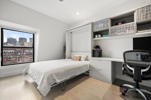 bedroom with a city view and light wood finished floors