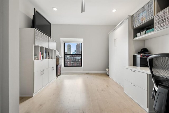 unfurnished office featuring light wood-type flooring, baseboards, recessed lighting, and built in study area