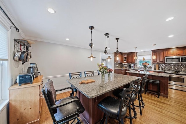 57 Century Rd, Weymouth, MA 02190 - kitchen featuring stainless steel appliances, a center island, a kitchen bar, backsplash, and recessed lighting