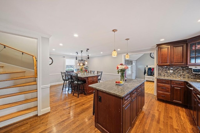 57 Century Rd, Weymouth, MA 02190 - kitchen with a center island, decorative backsplash, wood finished floors, glass insert cabinets, and recessed lighting