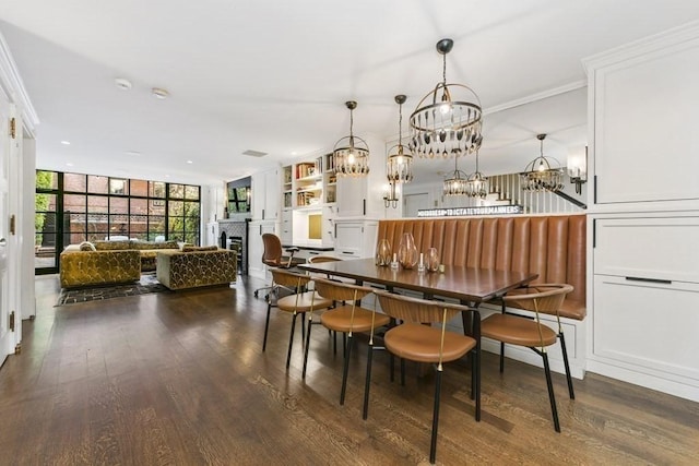 dining area featuring a fireplace, floor to ceiling windows, and dark wood finished floors