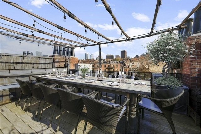 wooden terrace featuring a pergola, a city view, and outdoor dining space