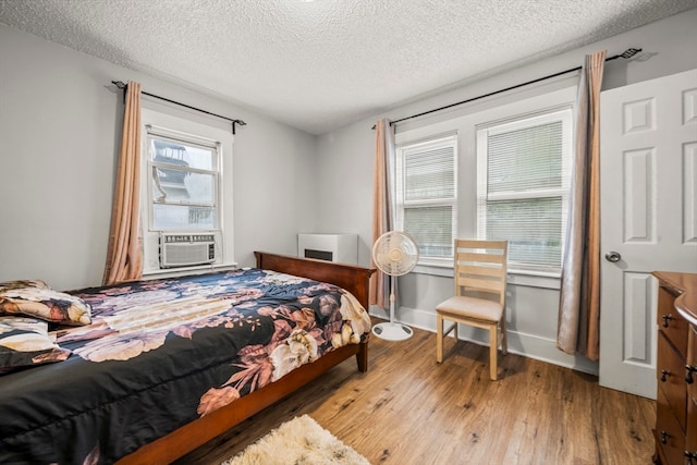 bedroom featuring light hardwood / wood-style flooring and a textured ceiling