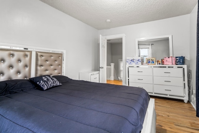 bedroom featuring light hardwood / wood-style floors and a textured ceiling