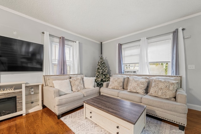 living room featuring dark hardwood / wood-style floors, ornamental molding, a wealth of natural light, and a textured ceiling