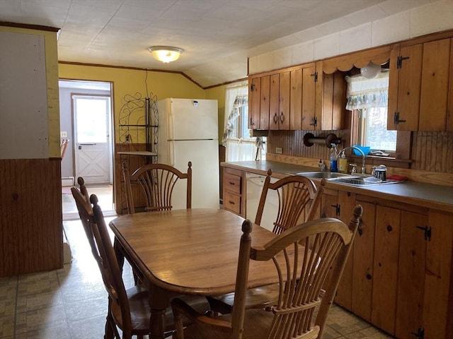 dining area featuring vaulted ceiling, sink, and a baseboard heating unit