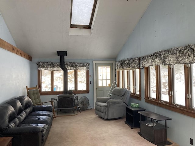 living room featuring lofted ceiling with skylight, light carpet, and a wood stove