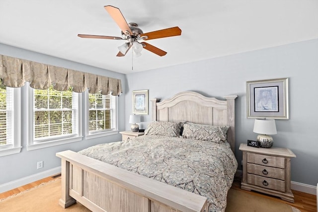 bedroom featuring baseboards, light wood-type flooring, and a ceiling fan