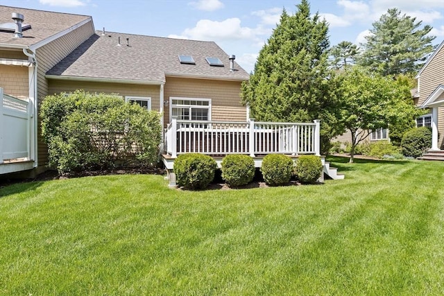 view of grassy yard with a wooden deck